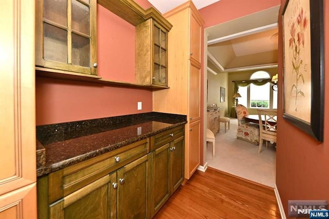 kitchen with hardwood / wood-style floors and dark stone countertops