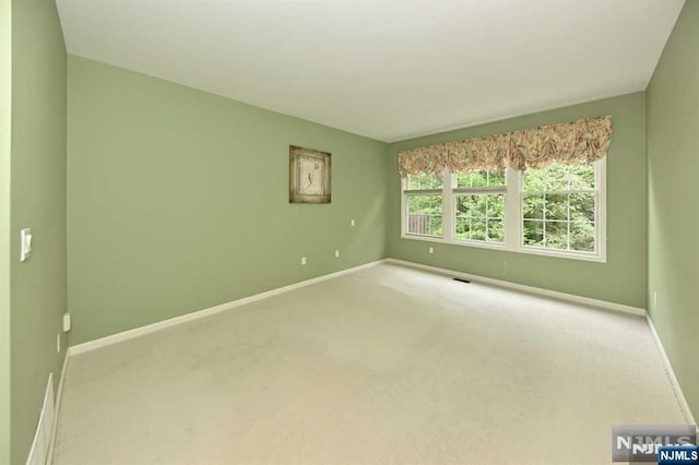 unfurnished room featuring light carpet