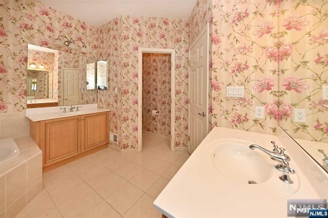 bathroom with vanity, tiled tub, and tile patterned floors