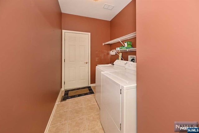 laundry area featuring washing machine and dryer and light tile patterned floors