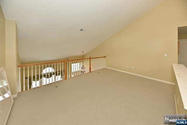 bonus room with vaulted ceiling and carpet