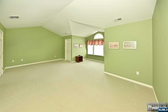 empty room with lofted ceiling and light colored carpet