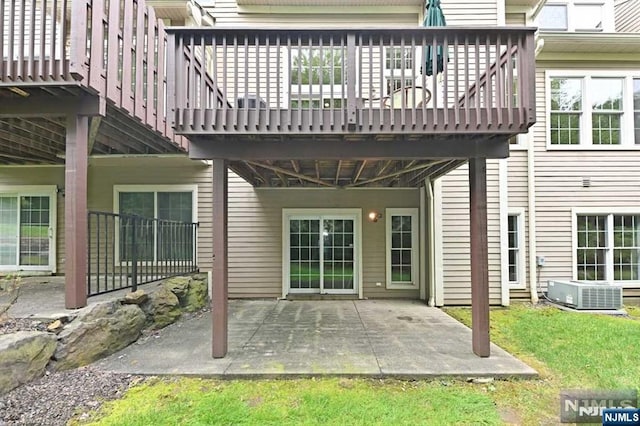 rear view of house with a wooden deck, central AC unit, and a patio area