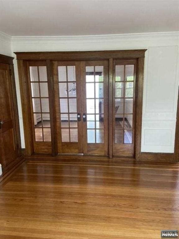 doorway with hardwood / wood-style flooring and ornamental molding