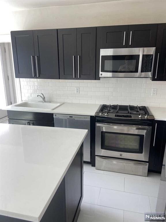 kitchen featuring appliances with stainless steel finishes, sink, and decorative backsplash