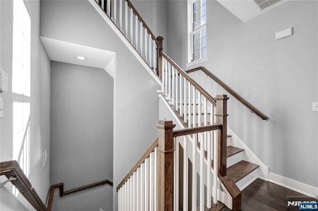 staircase featuring a high ceiling and hardwood / wood-style floors