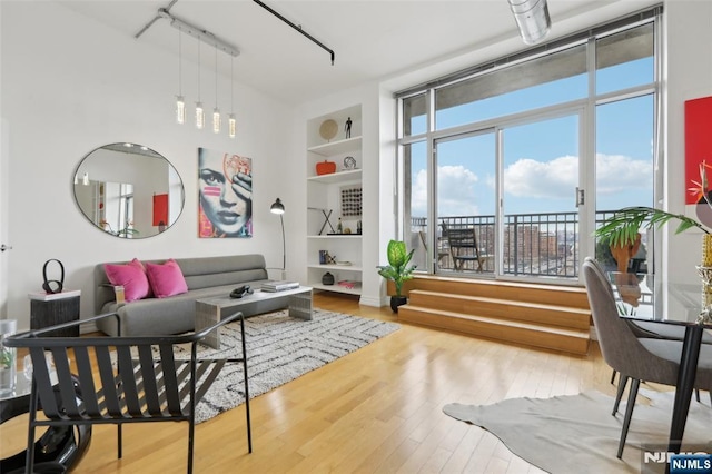 interior space with built in shelves and hardwood / wood-style floors