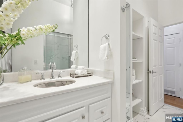 bathroom featuring vanity and a shower with door