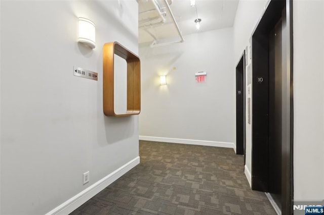 hall featuring dark colored carpet