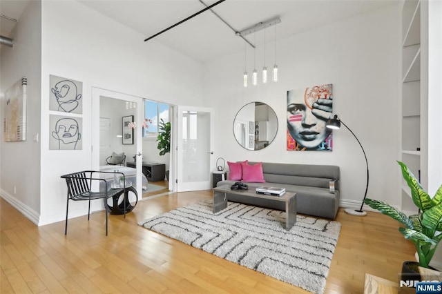 living area with wood-type flooring and a high ceiling