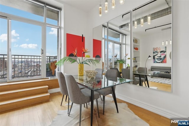 dining space featuring wood-type flooring and a notable chandelier