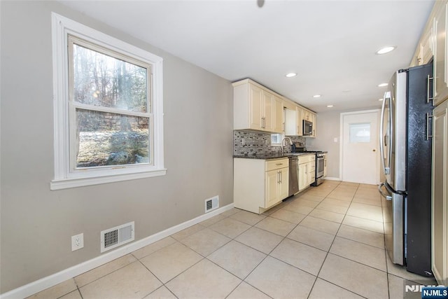 kitchen with light tile patterned flooring, stainless steel appliances, sink, and decorative backsplash