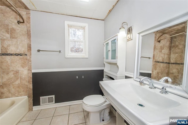 full bathroom featuring tiled shower / bath, toilet, tile patterned flooring, and sink