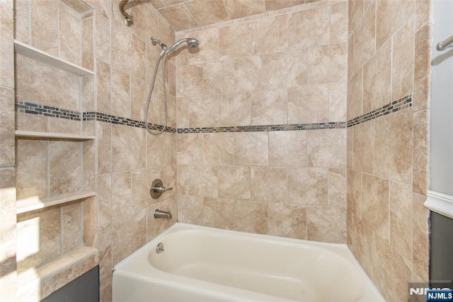 bathroom with tiled shower / bath combo