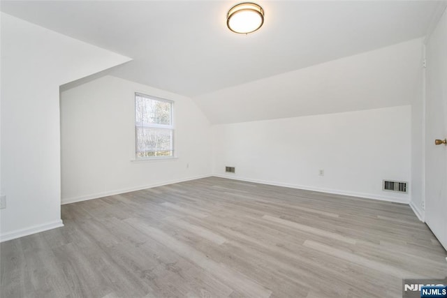 additional living space with lofted ceiling and light wood-type flooring