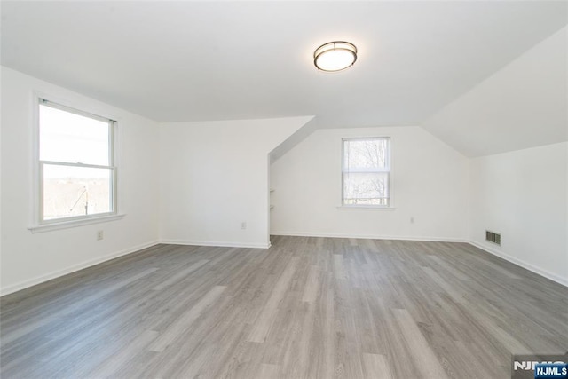 bonus room featuring vaulted ceiling and light hardwood / wood-style flooring