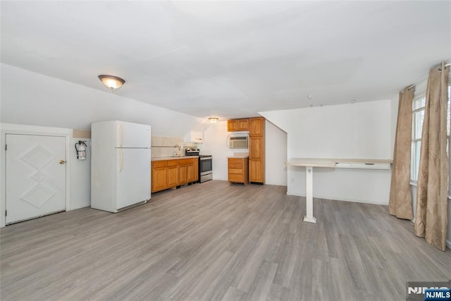 interior space featuring lofted ceiling, an AC wall unit, and light wood-type flooring