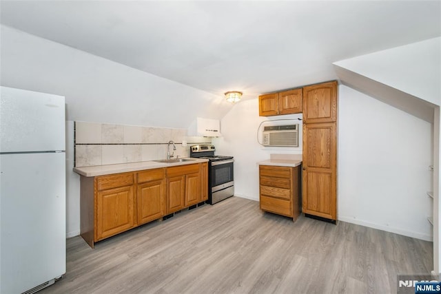 kitchen featuring sink, a wall mounted AC, white refrigerator, light wood-type flooring, and electric stove