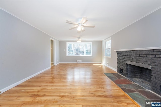 unfurnished living room with ceiling fan, ornamental molding, a fireplace, and light hardwood / wood-style floors