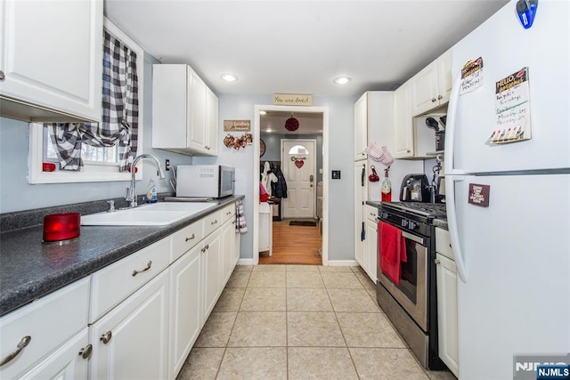 kitchen with white fridge, sink, stainless steel gas range, and white cabinets