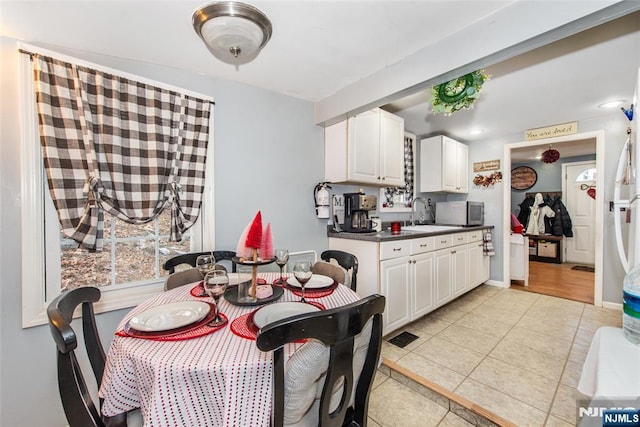 kitchen with white cabinetry, sink, and light tile patterned floors