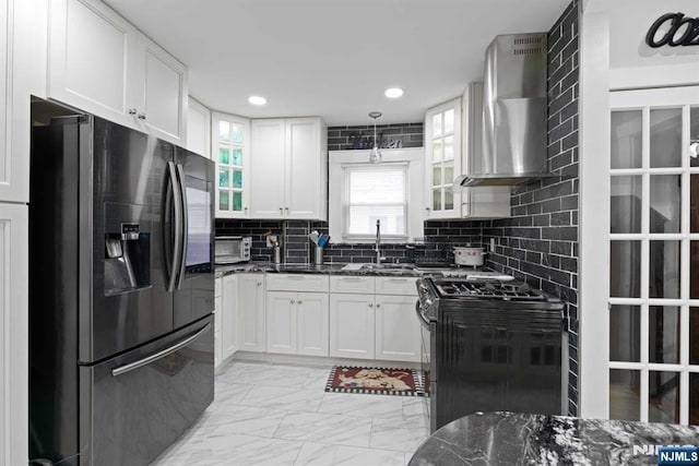 kitchen with stainless steel appliances, white cabinetry, wall chimney range hood, and decorative backsplash