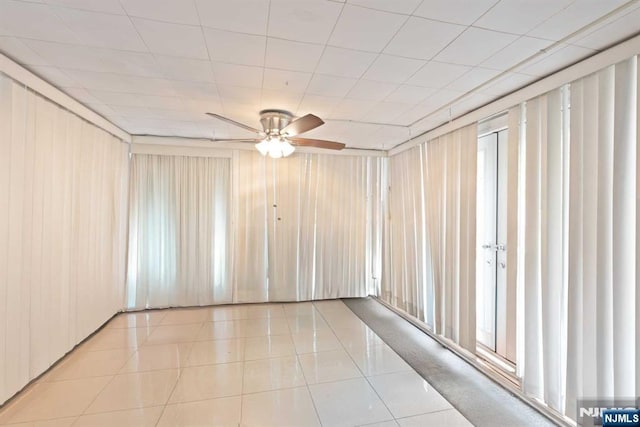 tiled empty room featuring ceiling fan