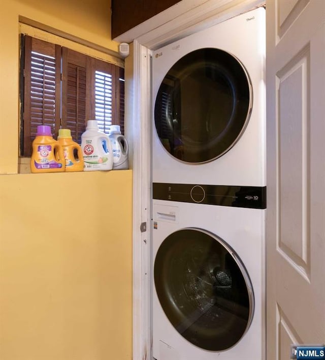 laundry room with stacked washer / dryer