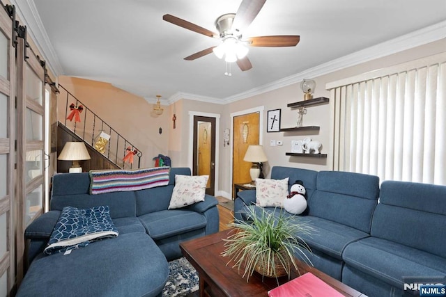 living room with ornamental molding, a barn door, hardwood / wood-style floors, and ceiling fan