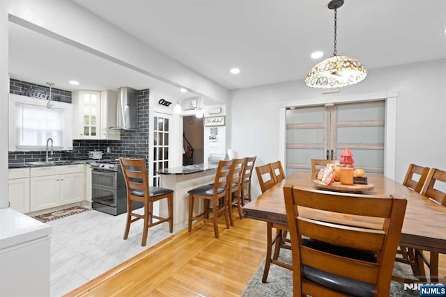 dining space with sink and light hardwood / wood-style floors