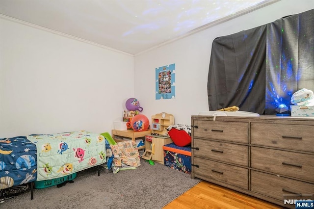 bedroom featuring ornamental molding and light hardwood / wood-style floors