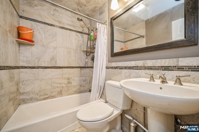 bathroom featuring tile walls, toilet, and shower / bath combo with shower curtain