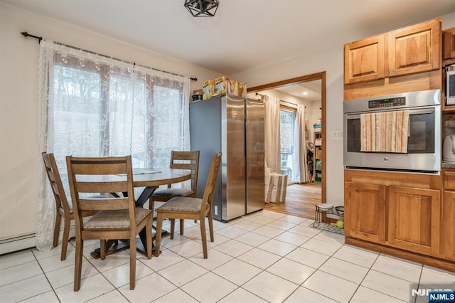 tiled dining room with a baseboard heating unit