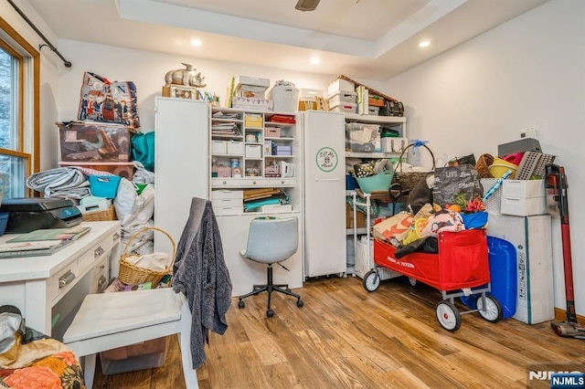 home office with light hardwood / wood-style flooring and ceiling fan