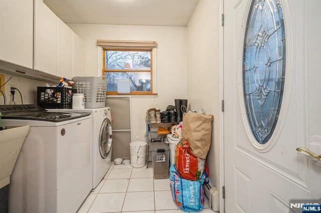 washroom with cabinets, washer and dryer, and light tile patterned floors