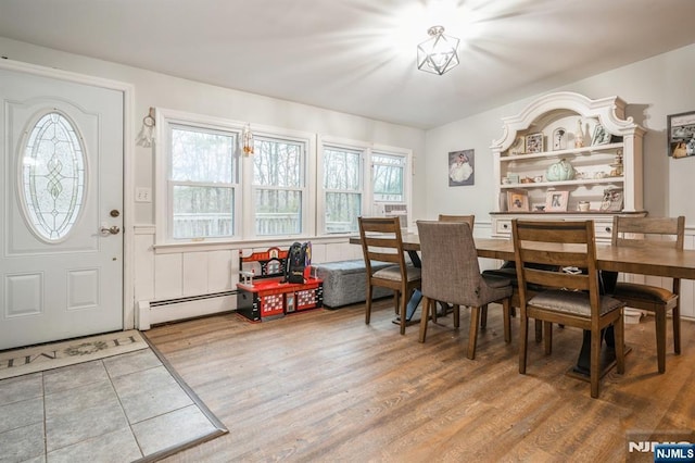 dining area featuring baseboard heating and hardwood / wood-style floors