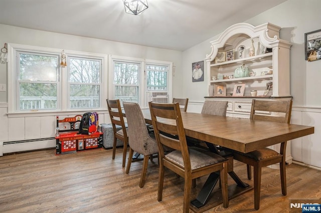 dining space with a baseboard radiator and hardwood / wood-style floors