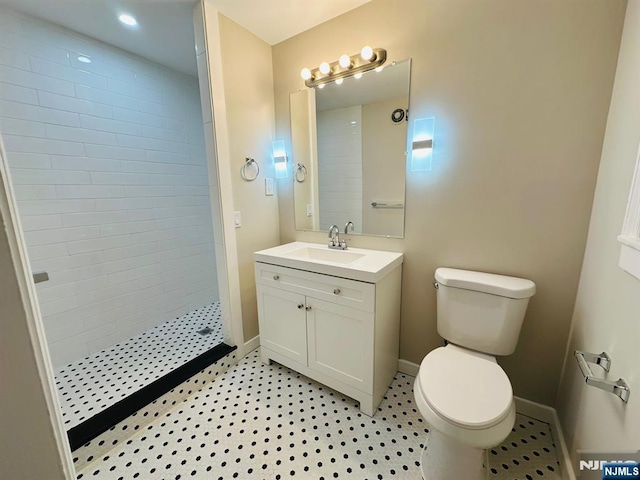 bathroom with vanity, toilet, and a tile shower