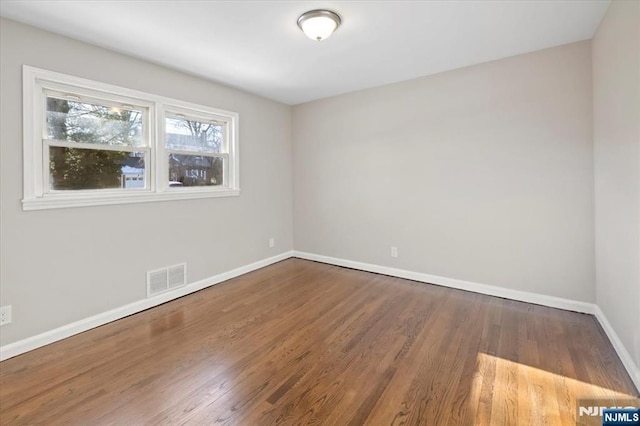 unfurnished room with dark hardwood / wood-style flooring