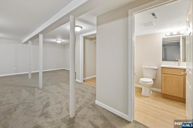 basement with sink and light colored carpet