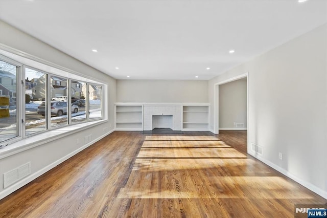 unfurnished living room featuring hardwood / wood-style flooring and a fireplace