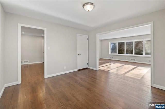 unfurnished room with dark hardwood / wood-style flooring