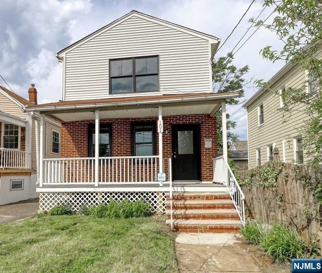 view of front of house featuring covered porch and a front yard