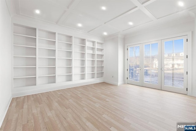 spare room featuring baseboards, coffered ceiling, built in features, and light wood-style floors