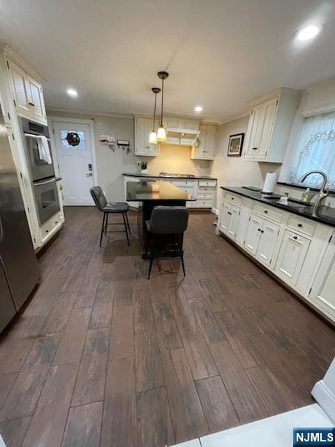 kitchen featuring dark hardwood / wood-style floors, white cabinets, and decorative light fixtures