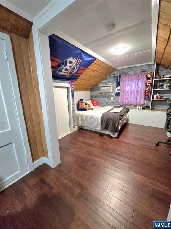 unfurnished bedroom featuring vaulted ceiling, dark wood-type flooring, and wood walls