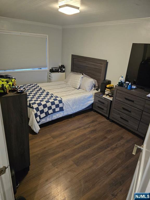 bedroom featuring crown molding and dark wood-type flooring