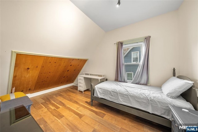 bedroom featuring lofted ceiling and light hardwood / wood-style flooring