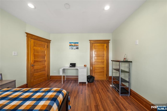 bedroom with dark hardwood / wood-style flooring