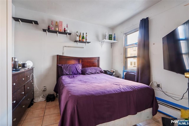 bedroom with a baseboard radiator and light tile patterned floors